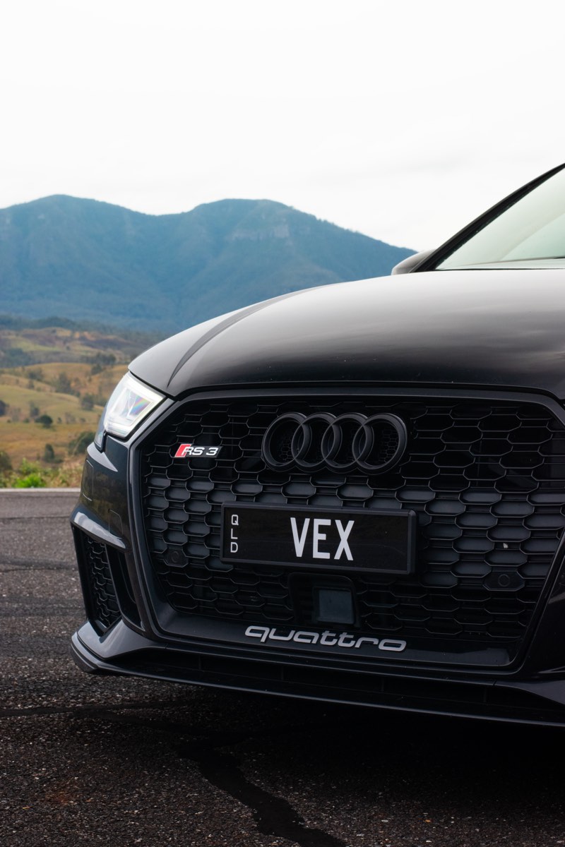 Close detail of the Audi RS3 grille with mountain backdrop
